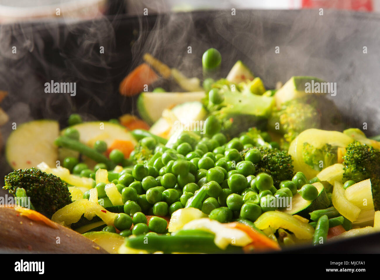 wok cooking with vegetables, carrots, zucchini, pole beans, broccoli, milk,  fresh and healthy Stock Photo - Alamy