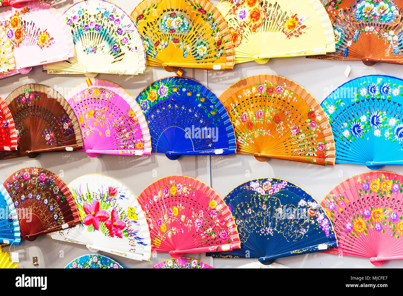 Wall full of beautiful Spanish handheld fans in all kinds of rainbow