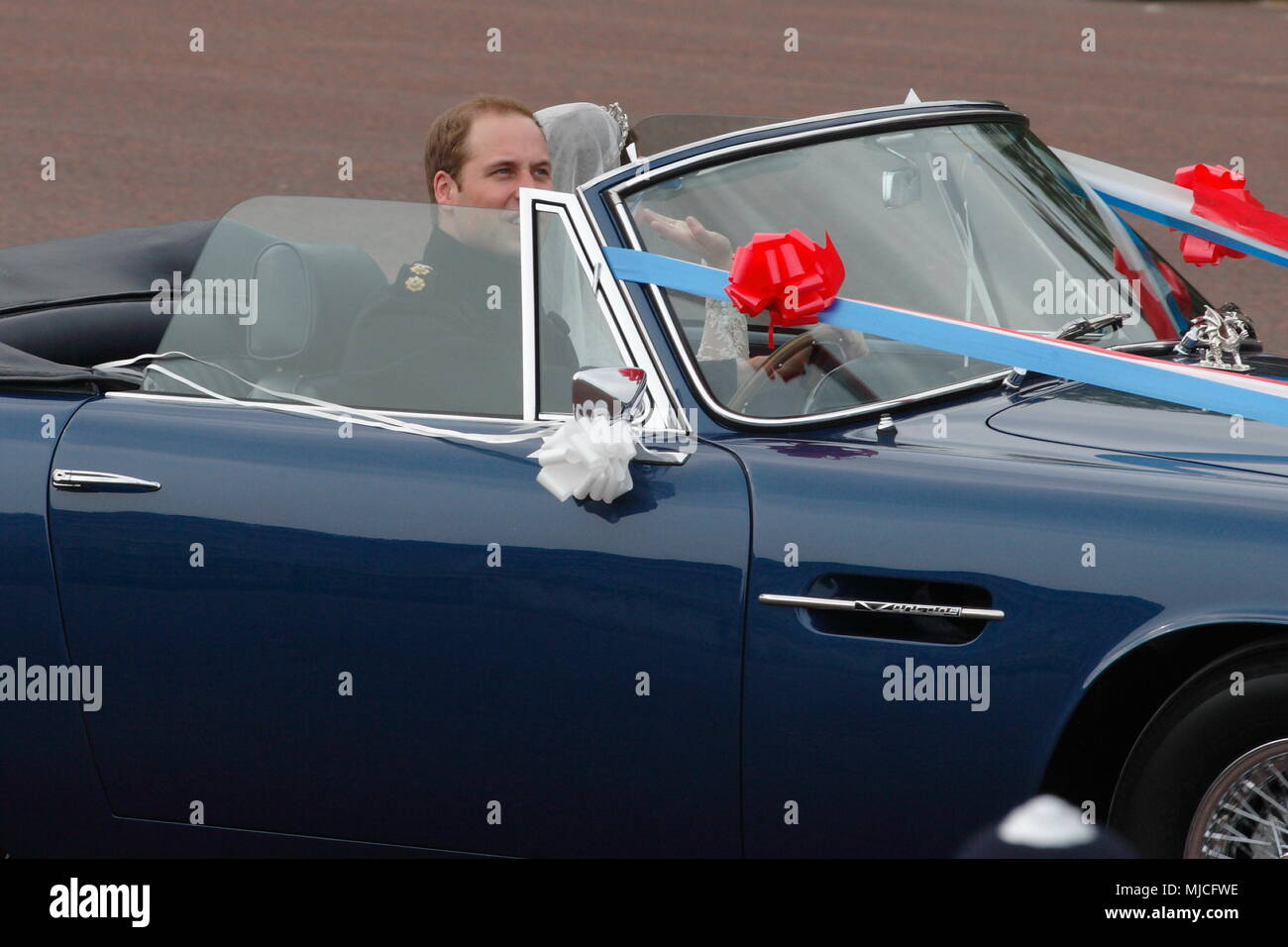 UK - Royal Wedding of Prince William and Kate (Catherine) Middleton - newlyweds William and Kate driving in an open top vintage Aston Martin Volante car along the Mall from  Buckingham Palace 29th April 2011 London UK Stock Photo