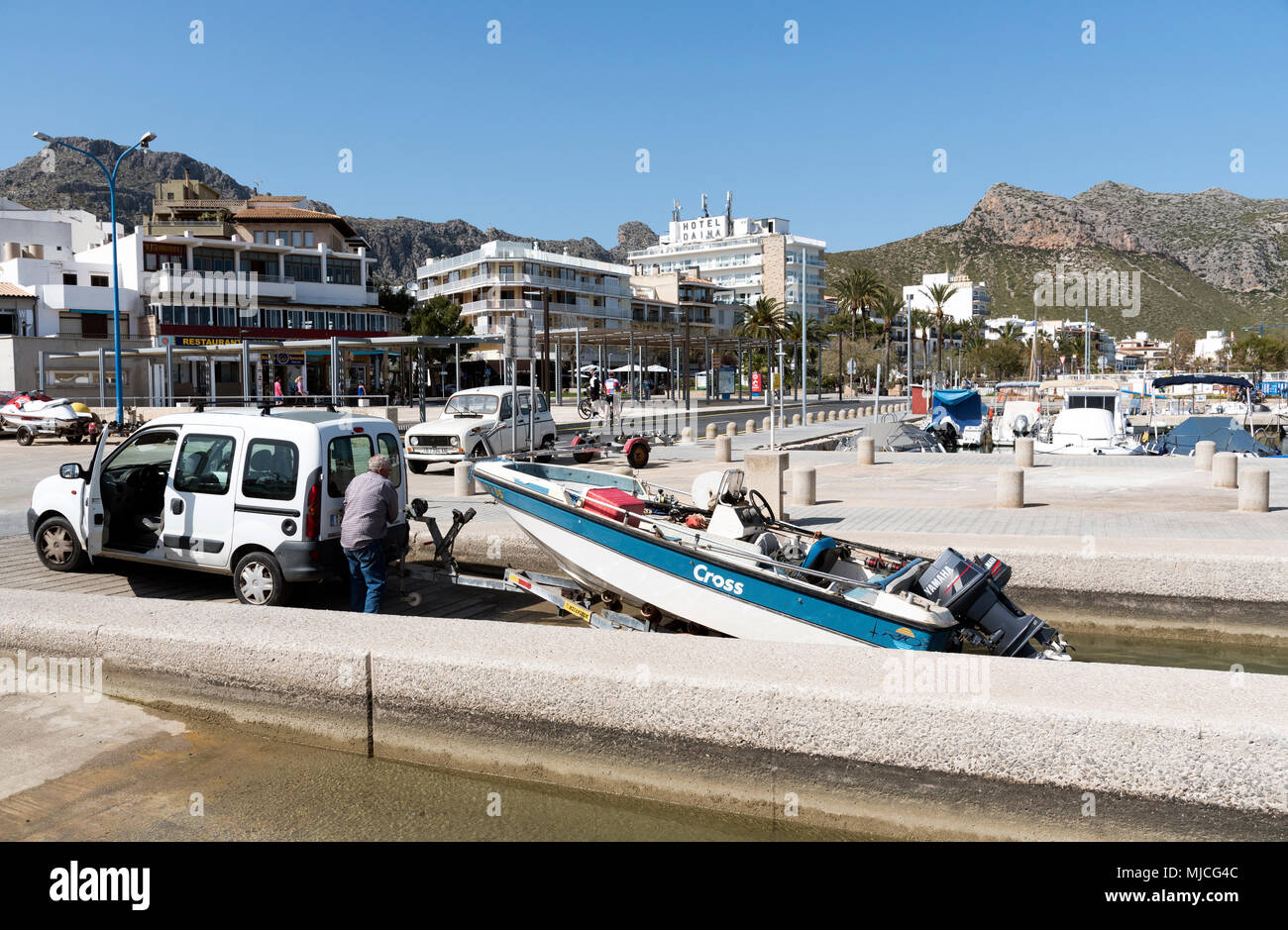 Port de Pollenca, Mallorca, Spain. 2018. Man winching a boat from the marina in this seaside town of Porto Pollenca, Mallorca. Stock Photo