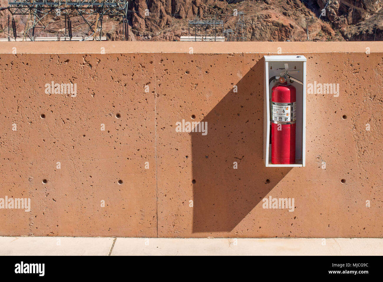 Fire extinguisher on the wall of parking building. The photo has very