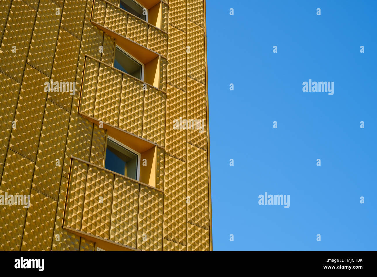 windows on building with golden facade and blue sky background Stock ...