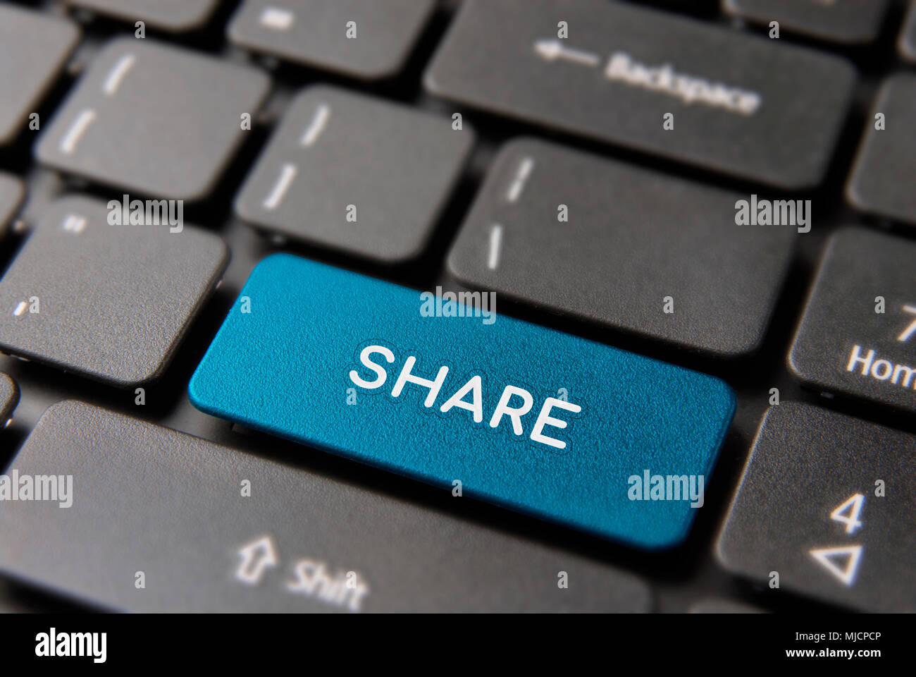 Share online content keyboard button for social media sharing concept. Network key closeup in blue color. Stock Photo