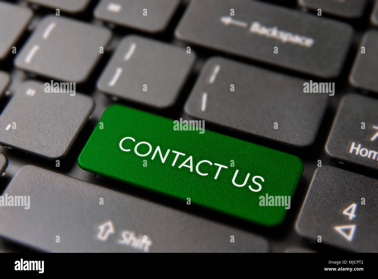 Contact us computer keyboard button for business service concept. Laptop icon key in green color. Stock Photo