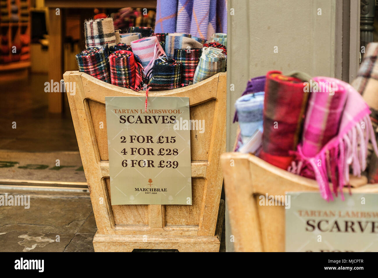 In a business numerous scarfs are offered in different variations in wooden boxes, Edinburgh, Highland, Scotland, Stock Photo