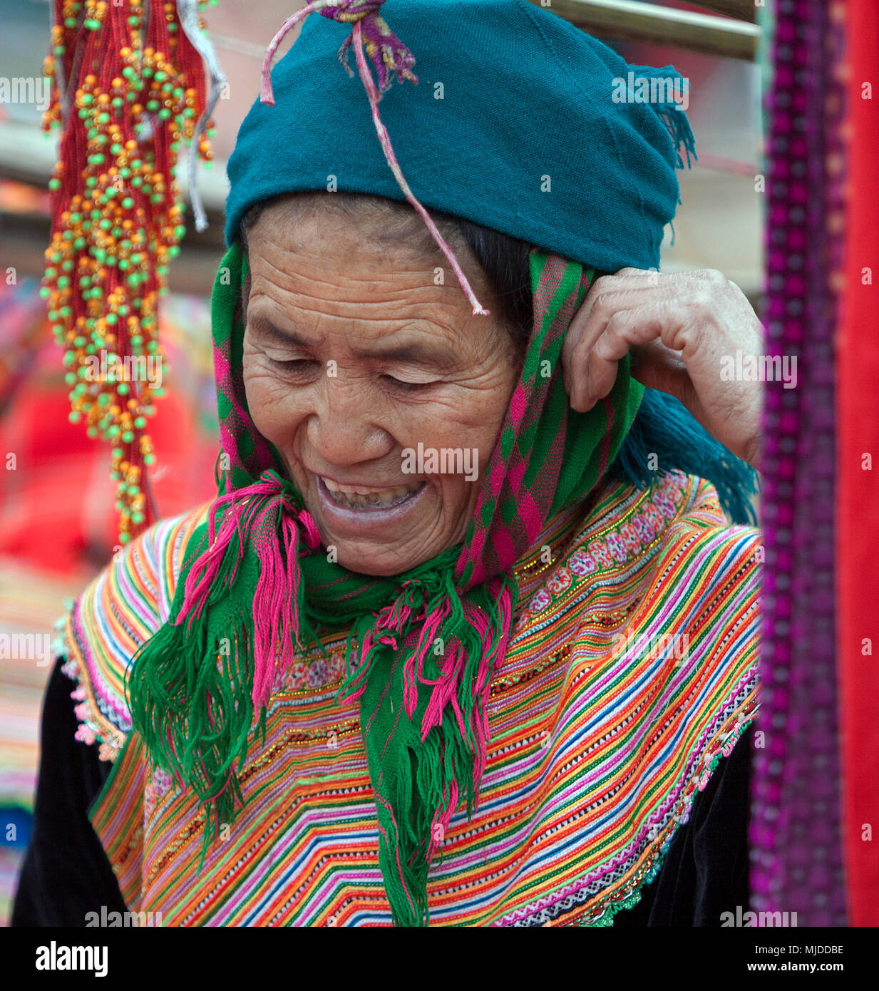 Woman dressed in traditional tribal dress with beads and weavings at Can Cao market near Sapa, Vietnam. Stock Photo