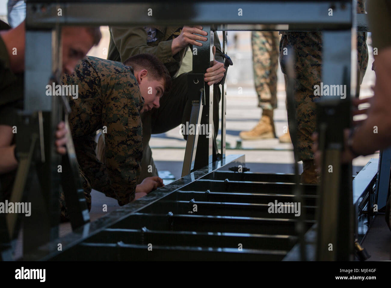 U.S. Marines assigned to Marine Aviation Weapons and Tactics Squadron 1 assemble an A/E32K-11 munitions lifting assembly during training in support of Weapons and Tactics Instructor course 2-18 at Marine Corps Air Station Yuma, Ariz., March 14. WTI is a seven-week training event hosted by MAWTS-1 cadre, which emphasizes operational integration of the six functions of Marine Corps aviation in support of a Marine Air Ground Task Force and provides standardized advanced tactical training and certification of unit instructor qualifications to support Marine Aviation Training and Readiness and assi Stock Photo