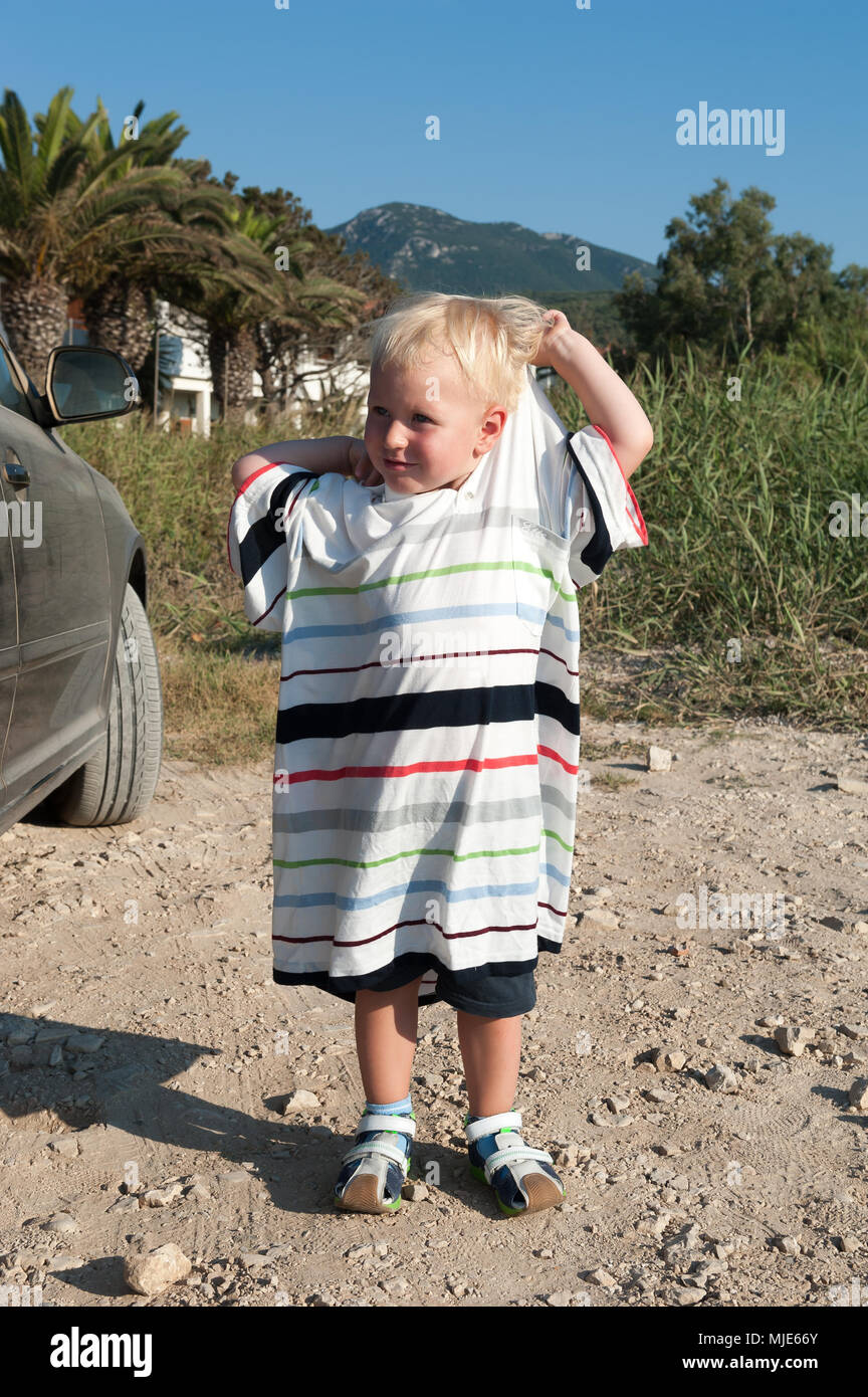 Two-year-old boy wearing a t-shirt for adult Stock Photo