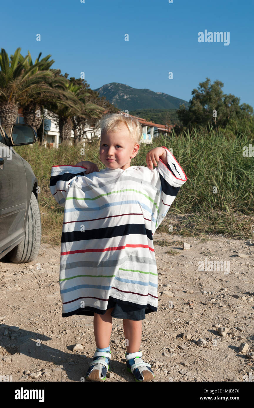 Two-year-old boy wearing a t-shirt for adult Stock Photo