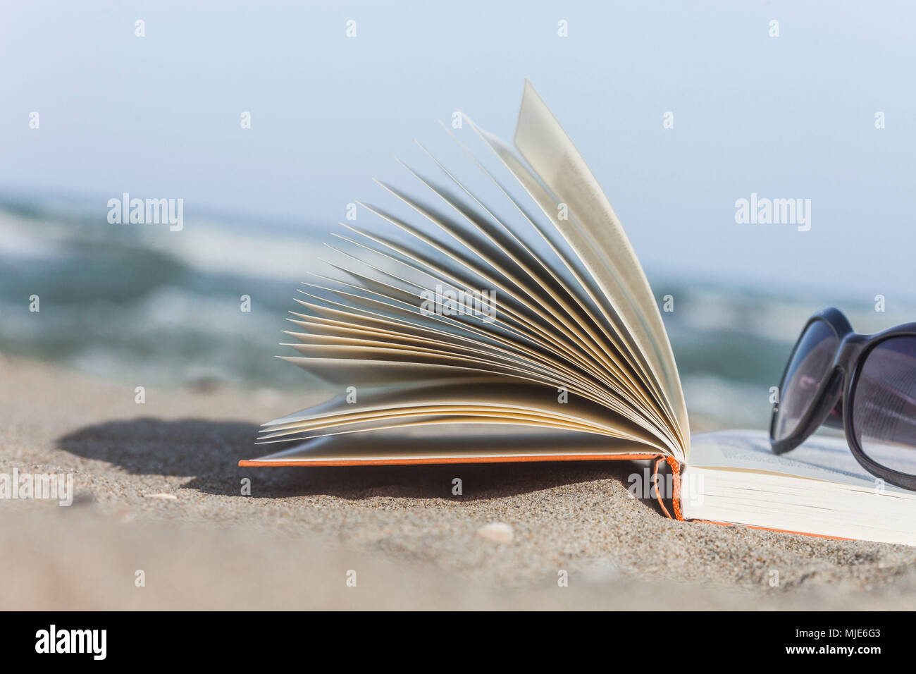 Book with sunglasses on the beach Stock Photo Alamy