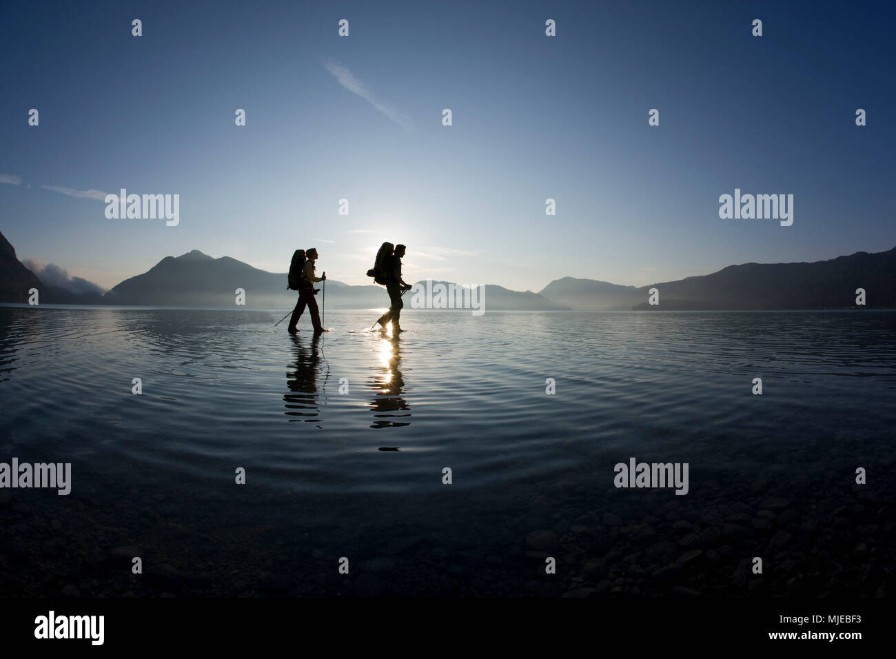 Hiker at Walchensee (Lake Walchen) in shallow water, Bavarian Alps, Bavaria, Germany Stock Photo