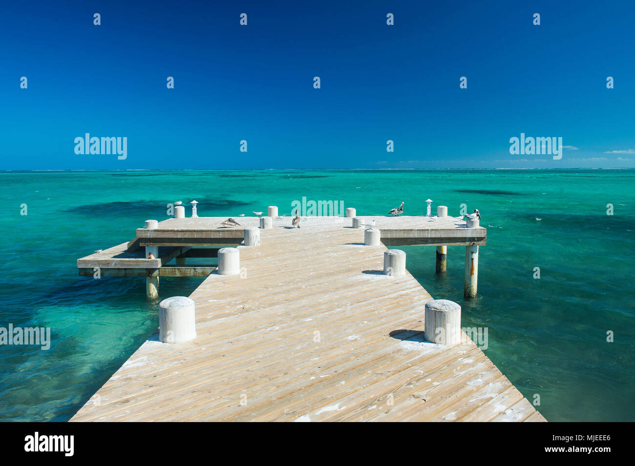Long wooden pier in the turquoise waters of Providenciales, Turks and Caicos Stock Photo