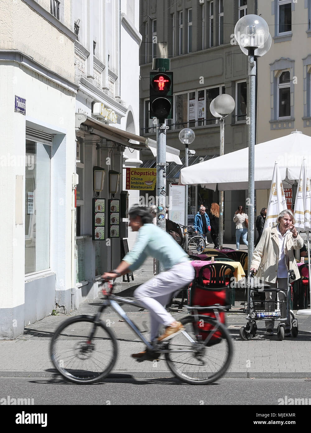 Trier, May 4. 5th May, 2018. A woman rides past the traffic light with the image of Karl Marx in Trier, Germany, May 4, 2018. The 200th anniversary of Karl Marx's birth falls on May 5, 2018. Credit: Shan Yuqi/Xinhua/Alamy Live News Stock Photo