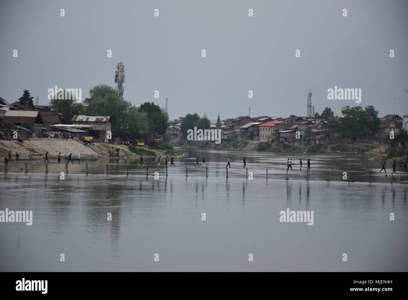 May 5, 2018 - Srinagar, Jammu & Kashmir, India - People walks over the wooden bridge to reach the Encounter site.4 Killed and several injured in an encounter between Indian forces and militants at chatabal area of Srinagar summer capital of Indian Kashmir on Saturday. Three militants were killed during a brief shootout after government forces laid seige around densely populated chatabal area of Srinagar. A young man also died after he was hit by the armoured vehicle during the clashes between the residents and police force as residents tried to help the Militants in escape. (Credit Image: © A Stock Photo