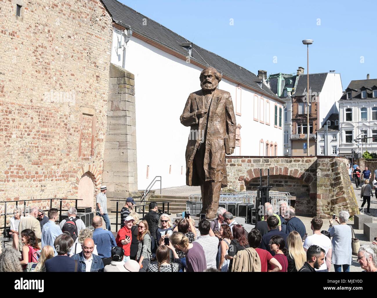 Trier, Germany. 5th May, 2018. Visitors gather in front of the Karl Marx statue in Trier, Germany, on May 5, 2018. A China-donated statue of German philosopher Karl Marx was unveiled on Saturday in his birth town on the 200th anniversary of his birth. Credit: Shan Yuqi/Xinhua/Alamy Live News Stock Photo