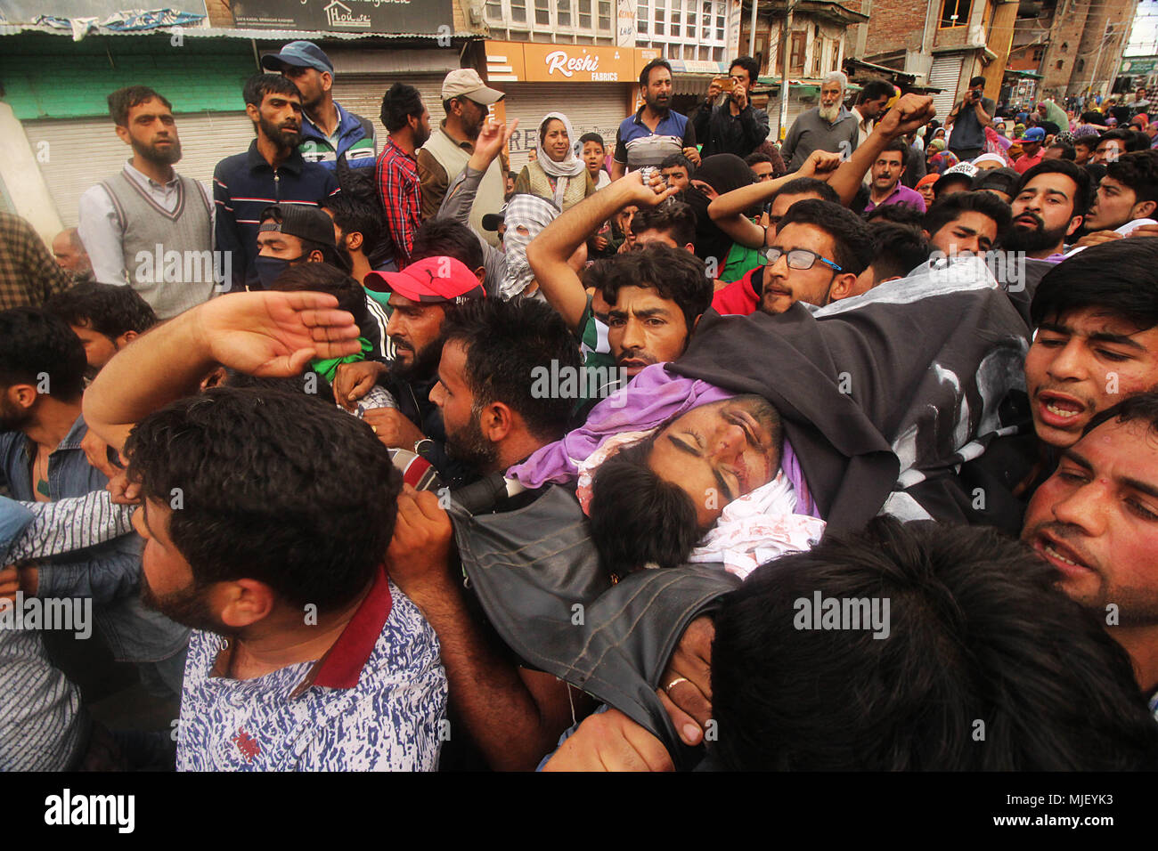 May 5, 2018 - Srinagar, Jammu and Kashmir, India - People carry the dead body of a protester who was ran over by police vehicle during anti-India clashes in Srinagar the summer of Indian controlled Kashmir on May 05, 2018. Four people including a protester and three rebels were killed during a gun-battle between rebels and Indian forces in Chattabal area of Srinagar. Massive clashes erupt across Srinagar after the news about the trapping of rebels and killing of protester spread across the city. Police fired teargas canisters, pellets, stun grenades and rubber coated bullets to disperse the an Stock Photo