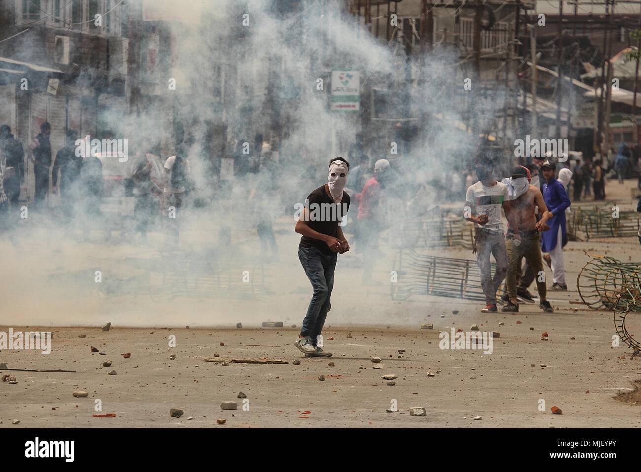 May 5, 2018 - Srinagar, Jammu and Kashmir, India - A protester throw stones during anti-India clashes in Srinagar the summer of Indian controlled Kashmir on May 05, 2018. Four people including a protester and three rebels were killed during a gun-battle between rebels and Indian forces in Chattabal area of Srinagar. Massive clashes erupt across Srinagar after the news about the trapping of rebels and killing of protester spread across the city. Police fired teargas canisters, pellets, stun grenades and rubber coated bullets to disperse the angry crowd. (Credit Image: © Faisal Khan via ZUMA Wir Stock Photo