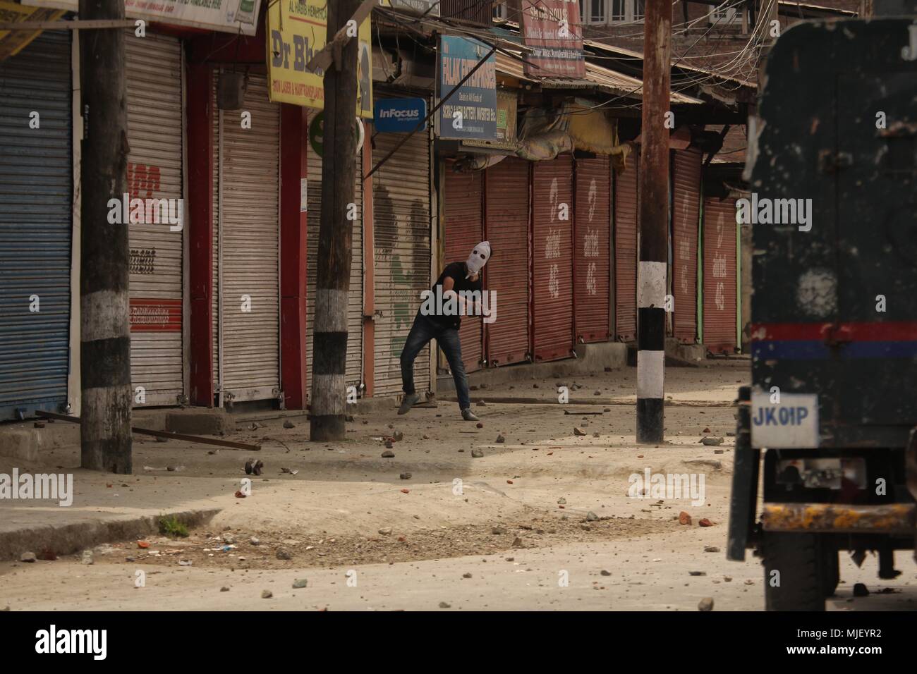 May 5, 2018 - Srinagar, Jammu and Kashmir, India - A protester throw stones during anti-India clashes in Srinagar the summer of Indian controlled Kashmir on May 05, 2018. Four people including a protester and three rebels were killed during a gun-battle between rebels and Indian forces in Chattabal area of Srinagar. Massive clashes erupt across Srinagar after the news about the trapping of rebels and killing of protester spread across the city. Police fired teargas canisters, pellets, stun grenades and rubber coated bullets to disperse the angry crowd. (Credit Image: © Faisal Khan via ZUMA Wir Stock Photo