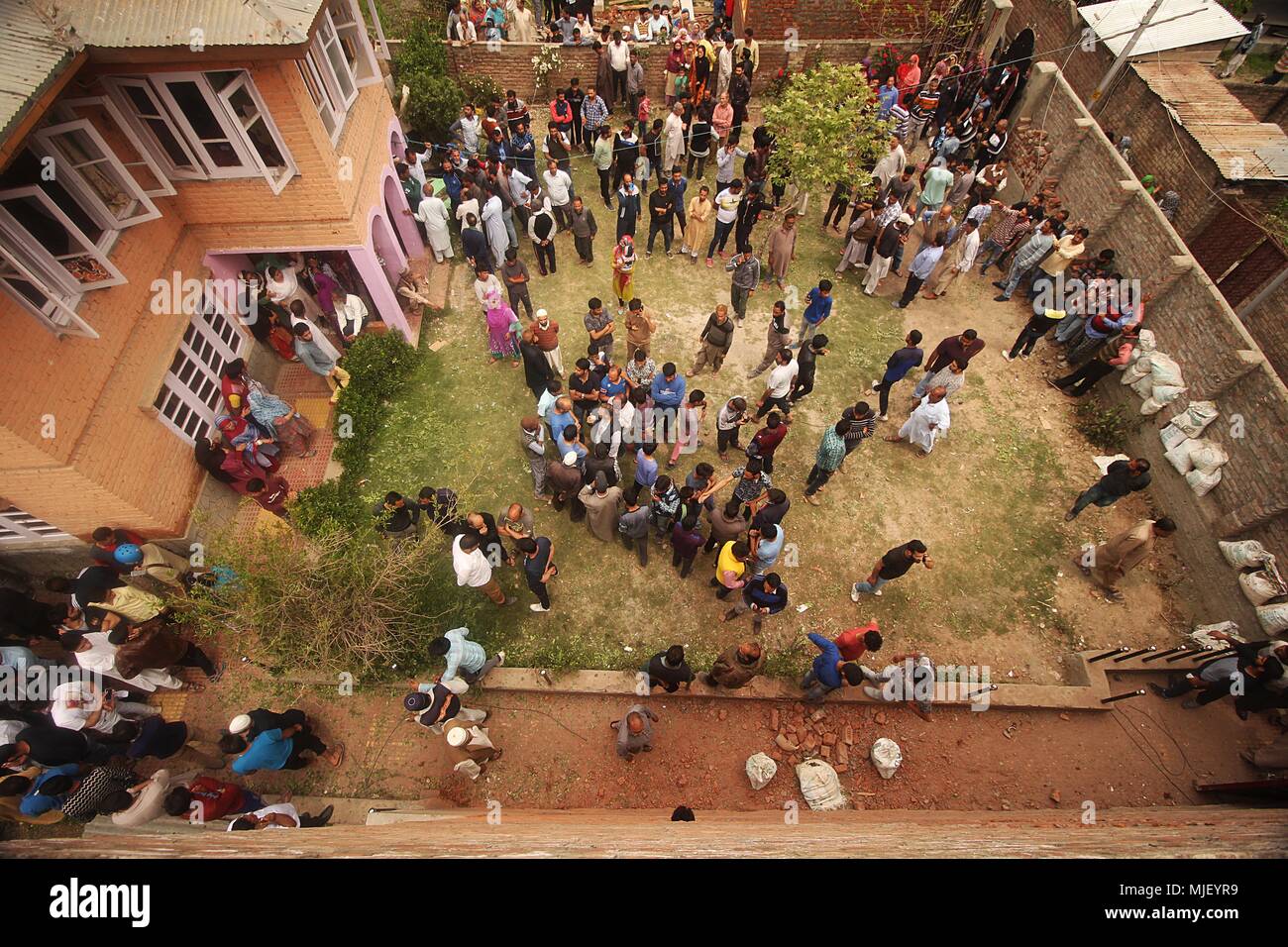 May 5, 2018 - Srinagar, Jammu and Kashmir, India - People gather infront of the house which was blasted by Indian security forces during a gun-battle in Srinagar the summer of Indian controlled Kashmir on May 05, 2018. Four people including a protester and three rebels were killed during a gun-battle between rebels and Indian forces in Chattabal area of Srinagar. Massive clashes erupt across Srinagar after the news about the trapping of rebels and killing of protester spread across the city. Police fired teargas canisters, pellets, stun grenades and rubber coated bullets to disperse the angry Stock Photo