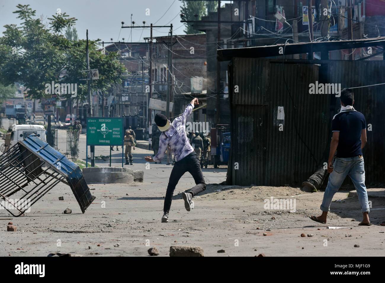 Kashmir, India, 5 May 2018.  Kashmiri protesters throw stones towards Indian government forces during clashes near the encounter site in Srinagar, Indian administered Kashmir. Three suspected militants and one civilian have been killed while three Indian paramilitary men sustained injuries in a gun battle in Srinagar, the summer capital of Indian administered Kashmir. The encounter started after government forces cordoned off a Chattabal area following the presence of militants in the area, officials said.  the militants were bel Credit: ZUMA Press, Inc./Alamy Live News Stock Photo