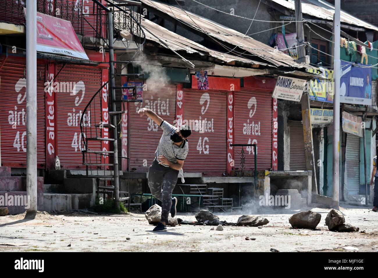 Kashmir, India, 5 May 2018.  A Kashmiri protester throw stones towards Indian government forces during clashes in Srinagar, Indian administered Kashmir. Three suspected militants and one civilian have been killed while three Indian paramilitary men sustained injuries in a gun battle in Srinagar, the summer capital of Indian administered Kashmir. The encounter started after government forces cordoned off a Chattabal area following the presence of militants in the area, officials said.  the militants were believed to be trapped. Th Credit: ZUMA Press, Inc./Alamy Live News Stock Photo