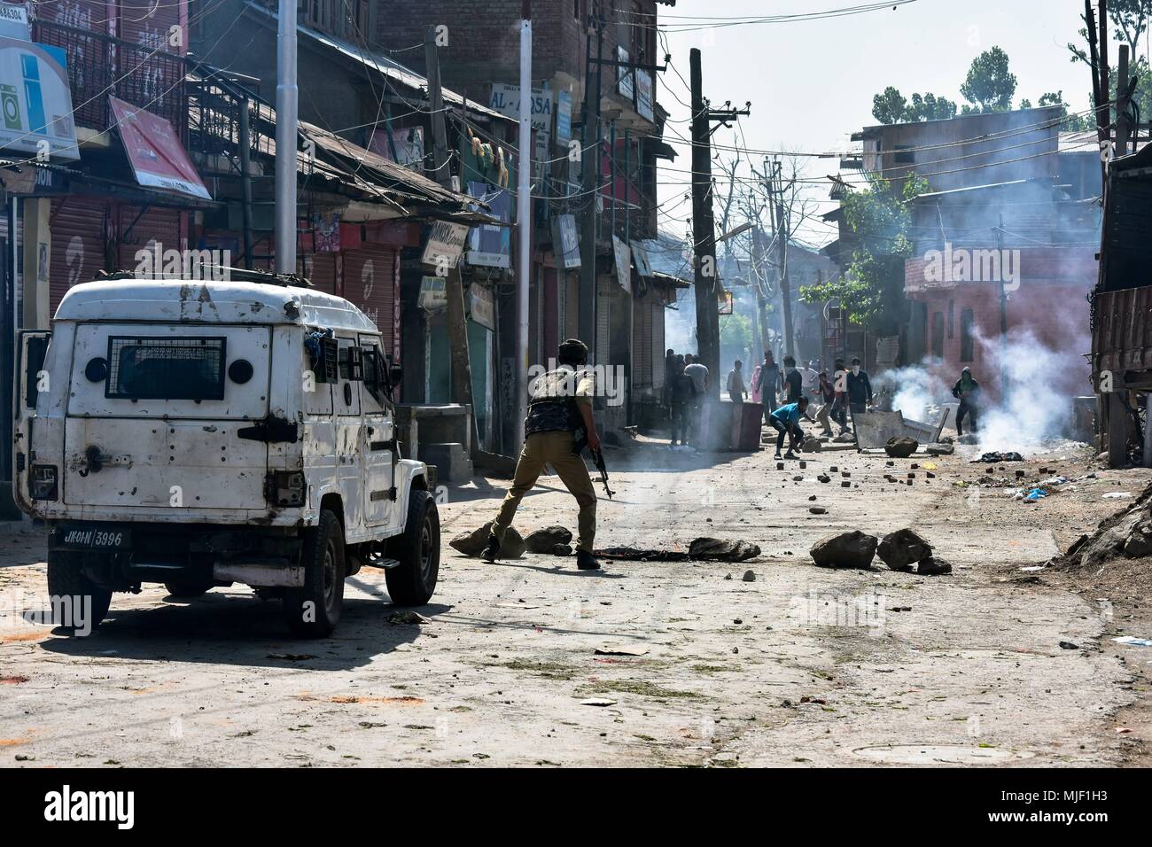 Kashmir, India, 5 May 2018.  Kashmiri protesters clash with Indian government forces near the encounter site in Srinagar, Indian administered Kashmir. Three suspected militants and one civilian have been killed while three Indian paramilitary men sustained injuries in a gun battle in Srinagar, the summer capital of Indian administered Kashmir. The encounter started after government forces cordoned off a Chattabal area following the presence of militants in the area, officials said.  the militants were believed to be trapped. The Credit: ZUMA Press, Inc./Alamy Live News Stock Photo