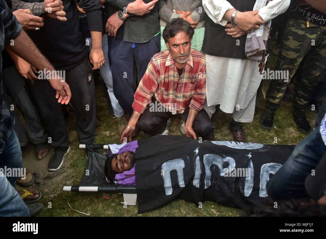 Kashmir, India, 5 May 2018.  (EDITORS NOTE: Image depicts death.) A father sits near the dead body of his son Adil Ahmad, a civilian who was run over and killed by a security force vehicle, during his funeral procession in Srinagar, Indian administered Kashmir. Three suspected militants and one civilian have been killed while three Indian paramilitary men sustained injuries in a gun battle in Srinagar, the summer capital of Indian administered Kashmir. The encounter started after government forces cordoned off a Chattabal area following the presence of militants in the area, official Credit: Z Stock Photo