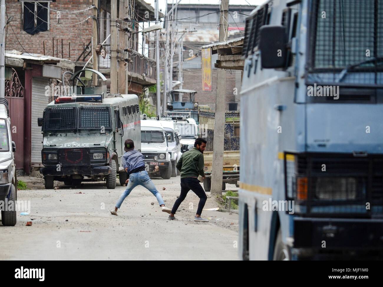 Kashmir, India, 5 May 2018.  Kashmiri protesters throw stones towards Indian police vehicles near the encounter site in Srinagar, Indian administered Kashmir. Three suspected militants and one civilian have been killed while three Indian paramilitary men sustained injuries in a gun battle in Srinagar, the summer capital of Indian administered Kashmir. The encounter started after government forces cordoned off a Chattabal area following the presence of militants in the area, officials said.  the militants were believed to be trapp Credit: ZUMA Press, Inc./Alamy Live News Stock Photo