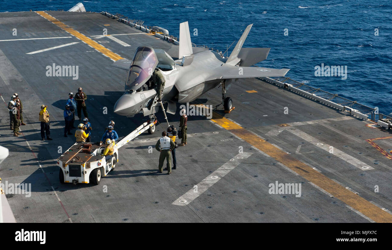 PHILIPPINE SEA (March 23, 2018) Sailors prepare to tow an F-35B Lightning II on the flight deck of the amphibious assault ship USS Wasp (LHD 1). Wasp, part of the Wasp Expeditionary Strike Group, with embarked 31st Marine Expeditionary Unit, is operating in the Indo-Pacific region to enhance interoperability with partners, serve as a ready-response force for any type of contingency and advance the Up-Gunned ESG Concept. (U.S. Navy Stock Photo