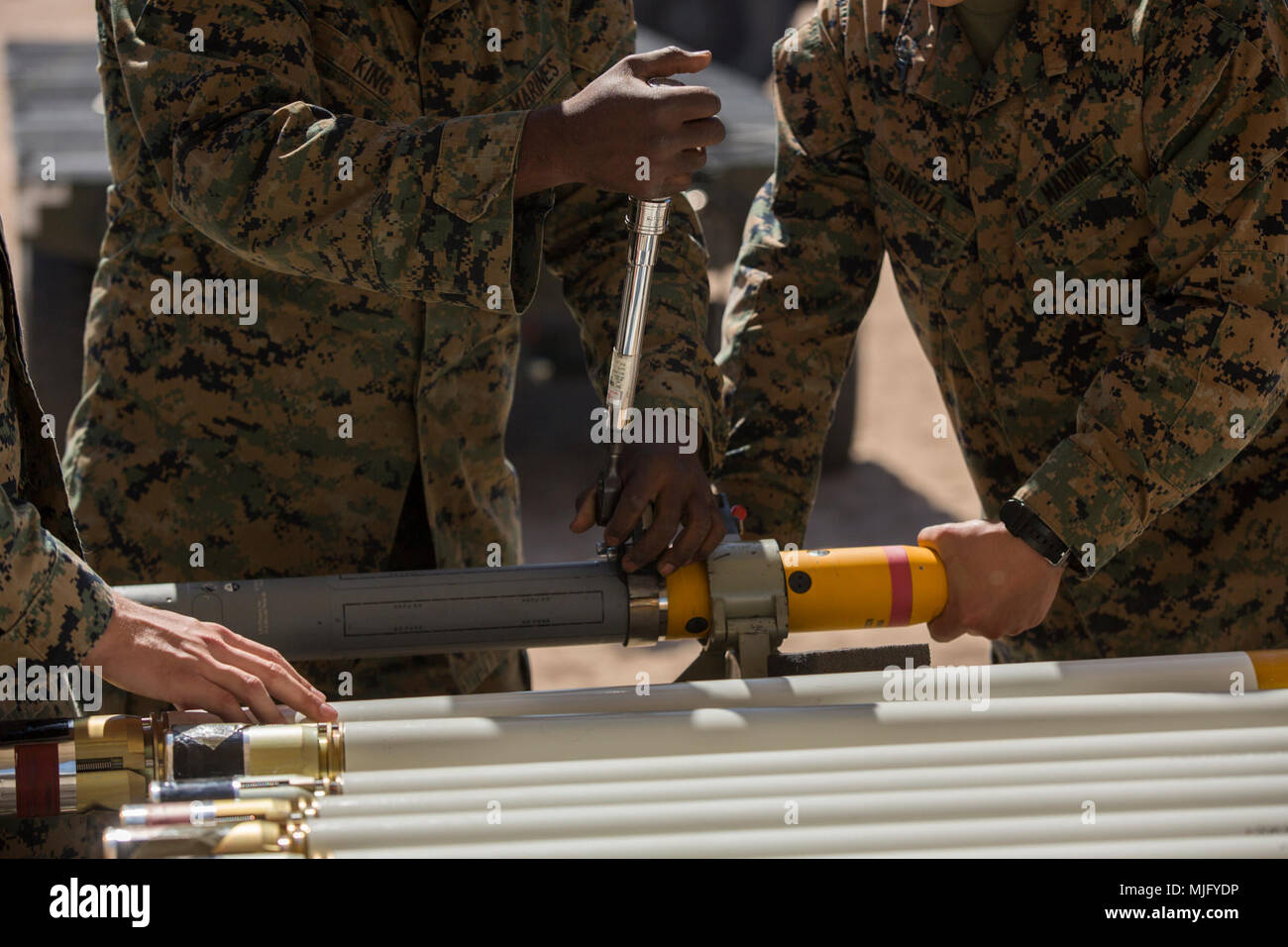 U.S. Marines assigned to Marine Aviation Weapons and Tactics Squadron 1 use a torque wrench to assemble a 2.75-inch rocket guidance unit configured with Advanced Precision Kill Weapon System II utilizing a M282 High Explosive Incendiary Multipurpose Penetrator Warhead during ordnance building and preparation in support of Weapons and Tactics Instructor course 2-18 at Marine Corps Air Station Yuma, Ariz., March 28. WTI is a seven-week training event hosted by MAWTS-1 cadre, which emphasizes operational integration of the six functions of Marine Corps aviation in support of a Marine Air Ground T Stock Photo