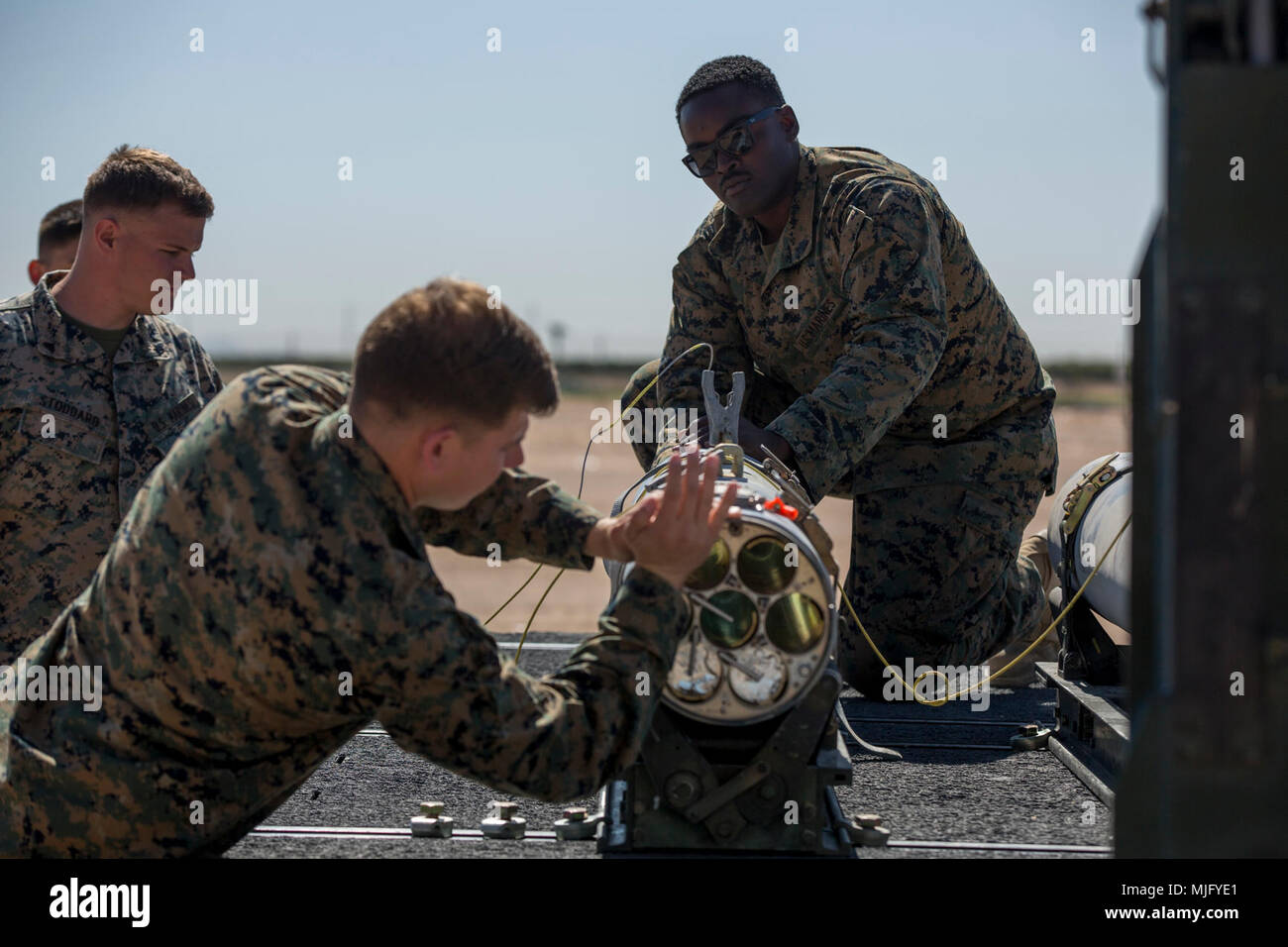 U.S. Marines assigned to Marine Aviation Weapons and Tactics Squadron 1 load a 2.75-inch rocket configured with Advanced Precision Kill Weapon System II, a hydra 70 rocket motor and M282 High Explosive Incendiary Multipurpose Penetrator Warhead into an LAU-68F/A rocket launcher during ordnance building and preparation in support of Weapons and Tactics Instructor course 2-18 at Marine Corps Air Station Yuma, Ariz., March 28. WTI is a seven-week training event hosted by MAWTS-1 cadre, which emphasizes operational integration of the six functions of Marine Corps aviation in support of a Marine Ai Stock Photo