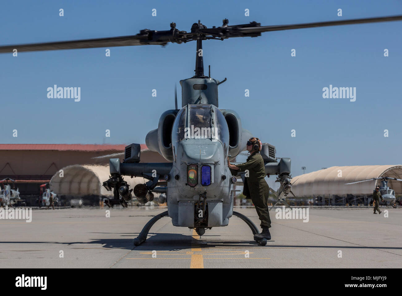 U.S. Marines assigned to Marine Aviation Weapons and Tactics Squadron 1 prepare an AH-1W Super Cobra during an Advanced Precision Kill Weapon System loading and flight takeoff exercise in support of Weapons and Tactics Instructor course 2-18 at Marine Corps Air Station Yuma, Ariz., March 29. WTI is a seven-week training event hosted by MAWTS-1 cadre, which emphasizes operational integration of the six functions of Marine Corps aviation in support of a Marine Air Ground Task Force and provides standardized advanced tactical training and certification of unit instructor qualifications to support Stock Photo