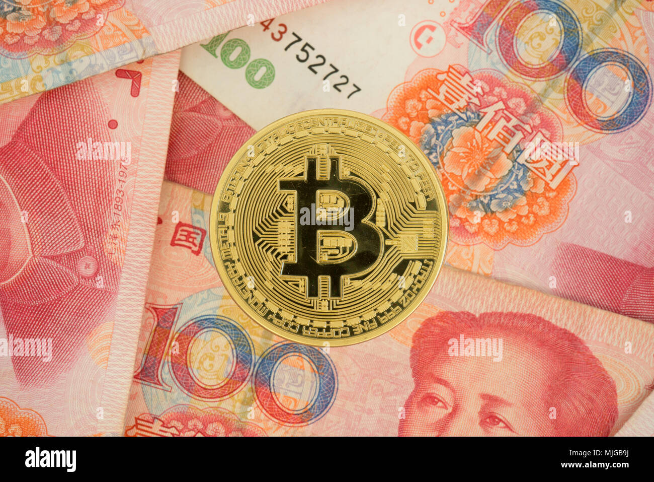 Real bitcoin coin on chinese yuan bills - crypto currency in china concept Stock Photo