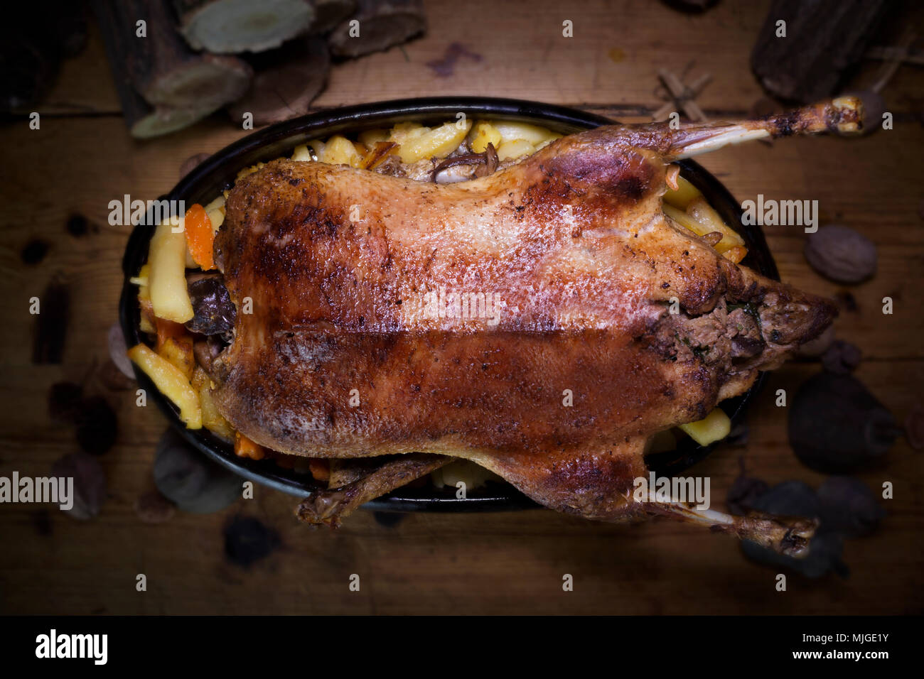 christmas-duck-roast-at-the-wooden-table-with-wood-logs-and-pine
