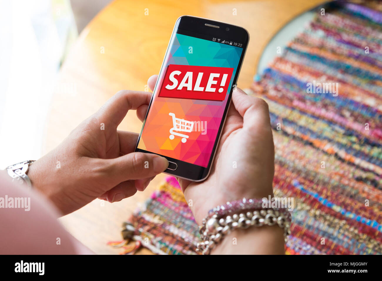 Girl holding a smartphone a sale advertising on the screen. Marketing, discount, internet, cell phone publicity. Stock Photo