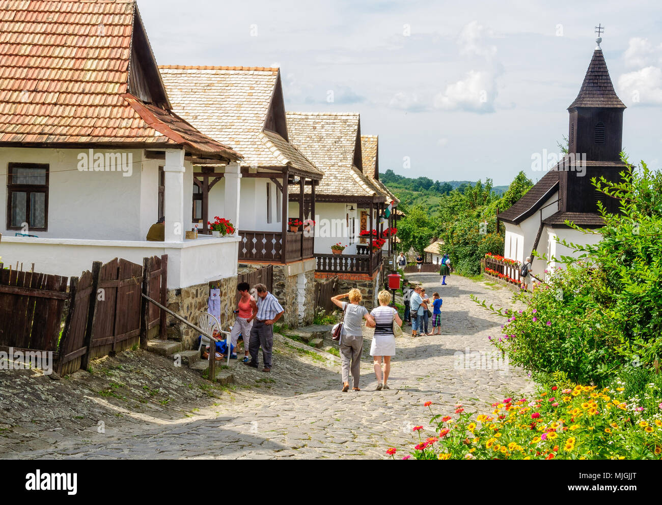 Visitors stroll along the Kossuth Street in the UNESCO World Heritage village - Holloko, Hungary Stock Photo