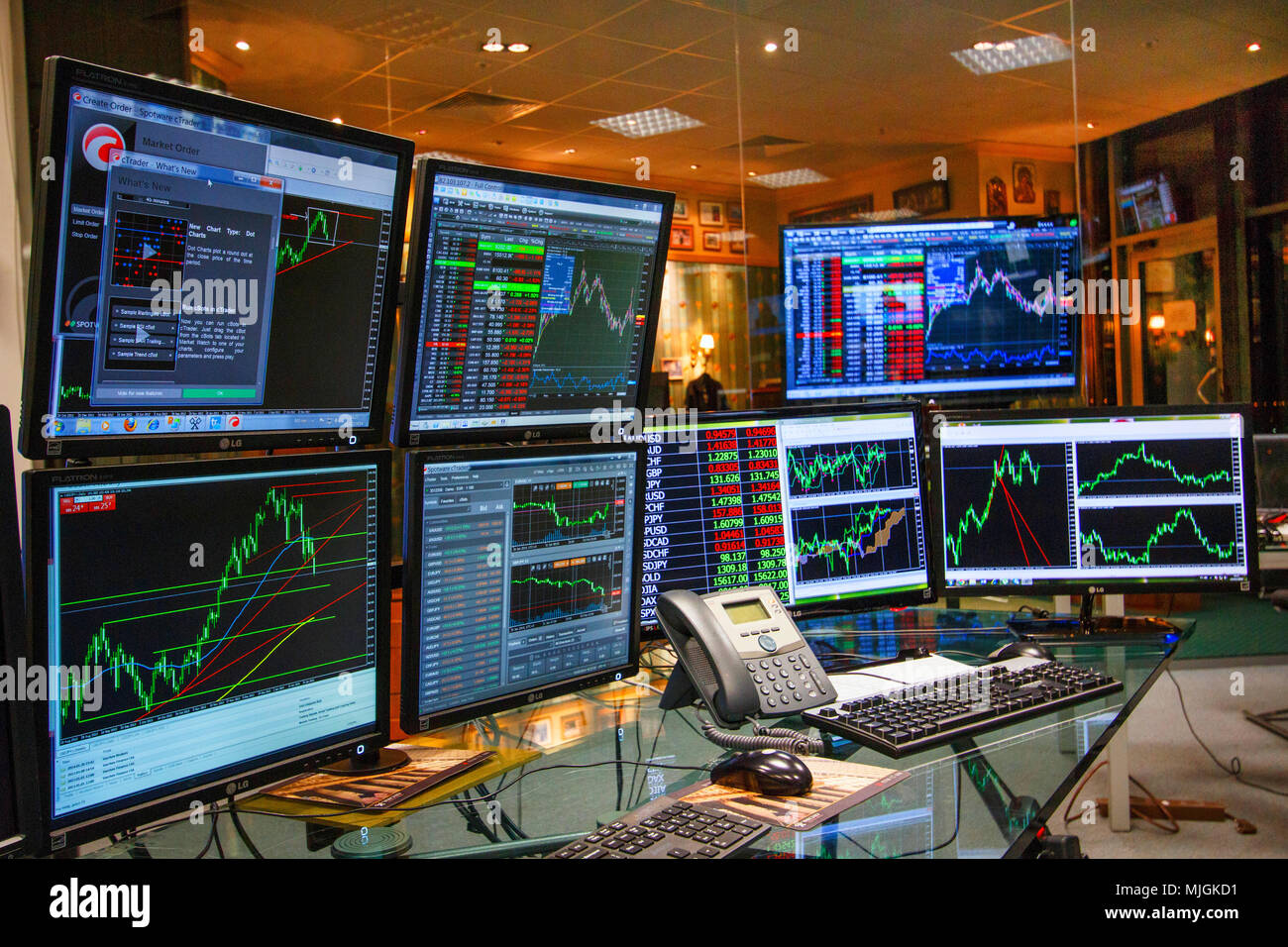Computer screens on desk showing charts and data analyses Stock Photo