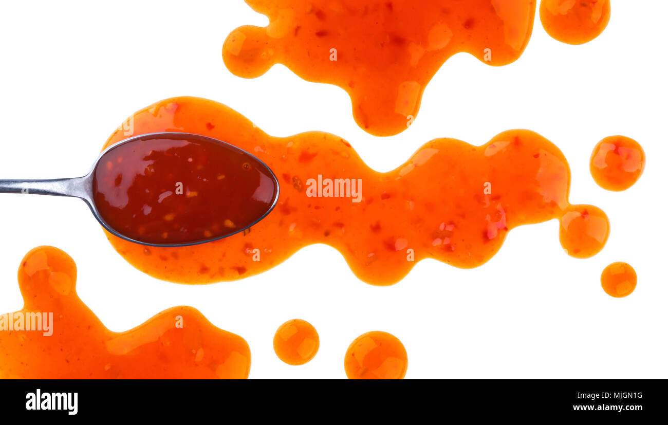 Sweet and sour sauce. Splashes and spilled orange sauce with spoon isolated on white background