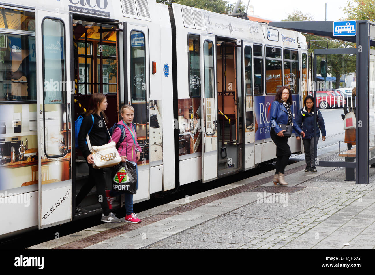 Trondheim, Norway - Sepember 30, 2016:  Passengers get off  an articulated tram at the tram stop on St. Oloavs gate in Trondheim city center. Stock Photo