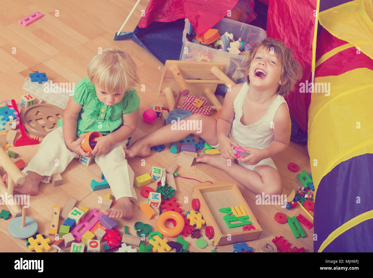 Two happy cute little girls playing with blocks in home interior Stock ...
