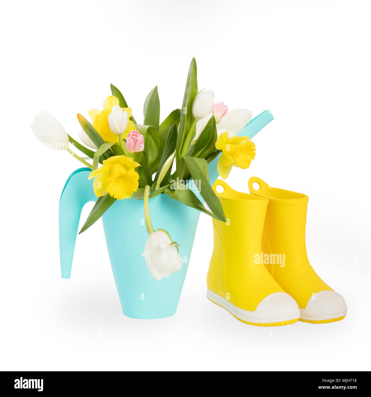 Yellow rubber boots and blue watering can with a bouquet of flowers of ...