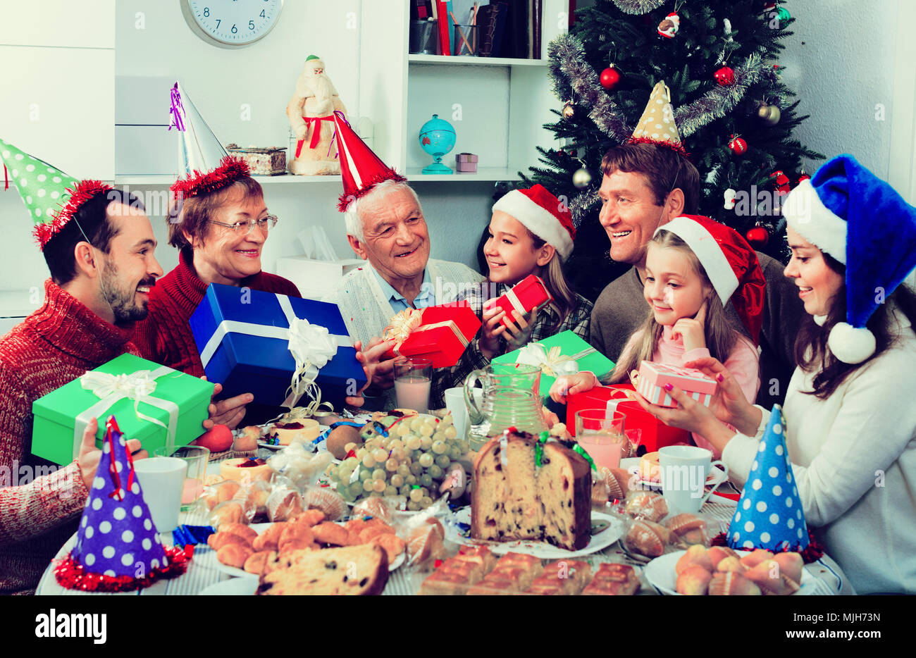 large-satisfied-friendly-smiling-family-exchanging-gifts-during