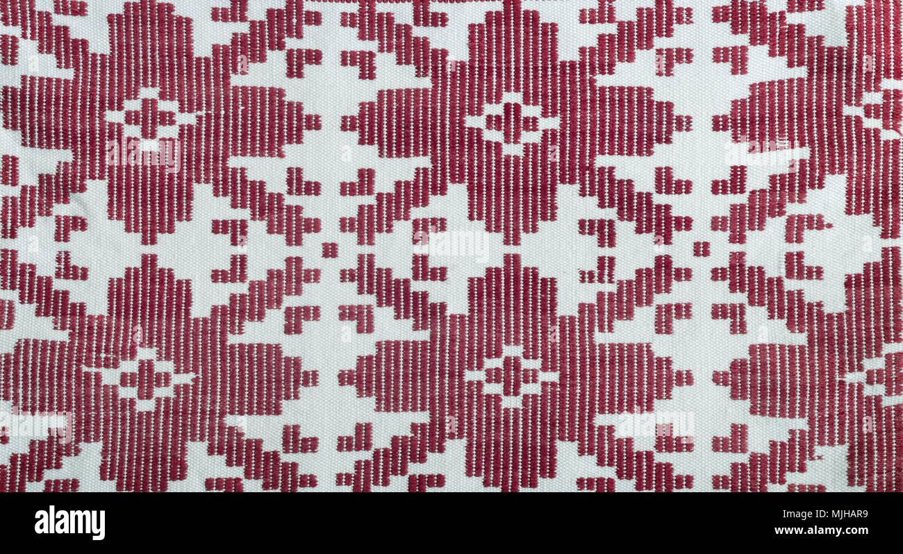 A fragment of ancient fabric with a beautiful pattern, made on a handmade loom. Stock Photo