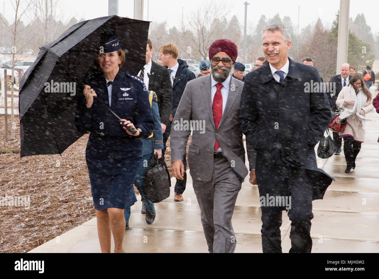 U.S. Air Force Lori J. Robinson, commander of the North American Aerospace Defense Command and U.S. Northern Command, Canadian Minister of National Defence Harjit Sajjan and NATO Secretary General Jens Stoltenberg walk into the commands’ headquarters building during an unexpected snow storm in Colorado Springs, Colorado, April 6. During their visit to the commands, the three leaders discussed their collective support and commitment to the defense of North America, as well as their gratitude for the opportunity to meet in-person and learn more about each other's respective mission-sets and prio Stock Photo