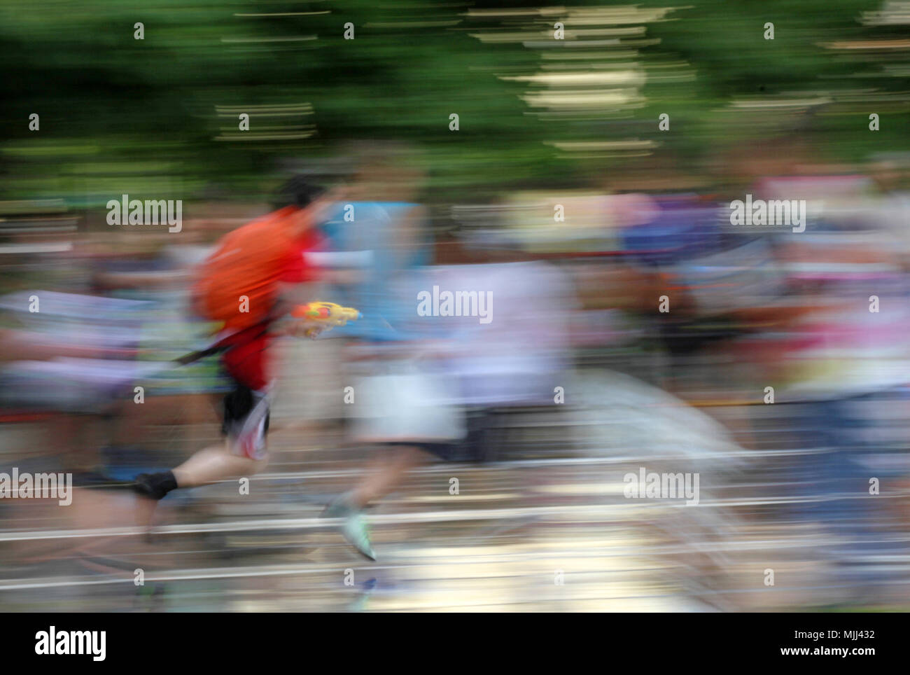 Motion blur picture of running man. Motion blurred photo with man running. Motion picture of running people background. Blurred wallpaper with running Stock Photo