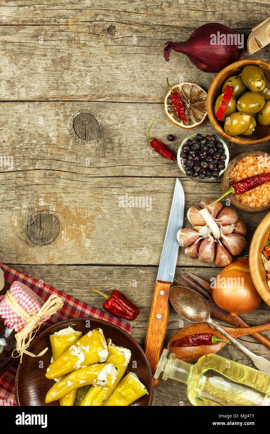 Food ingredients on a wooden background. Place for text. Restaurant menu. Recipe for chefs. Spices and stuffed green olives Stock Photo