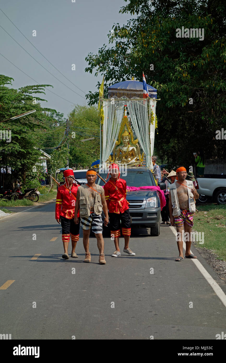 Songkran Thai New Year celebrations, four Thai men in ceremonial dress escort a pickup truck carrying golden Buddha statue, Udon Thani, Isaan, Thailand Stock Photo