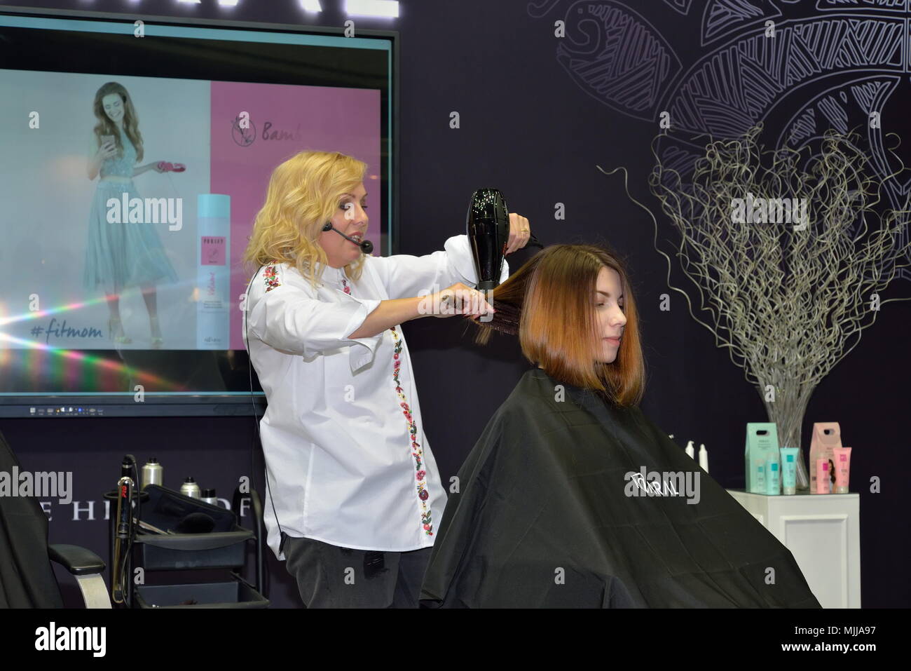 ST.PETERSBURG, RUSSIA - FEBRUARY 23, 2018: Stylist hair makes styling a client on a master class of beauty salon, Kaaral at the festival of beauty Nev Stock Photo