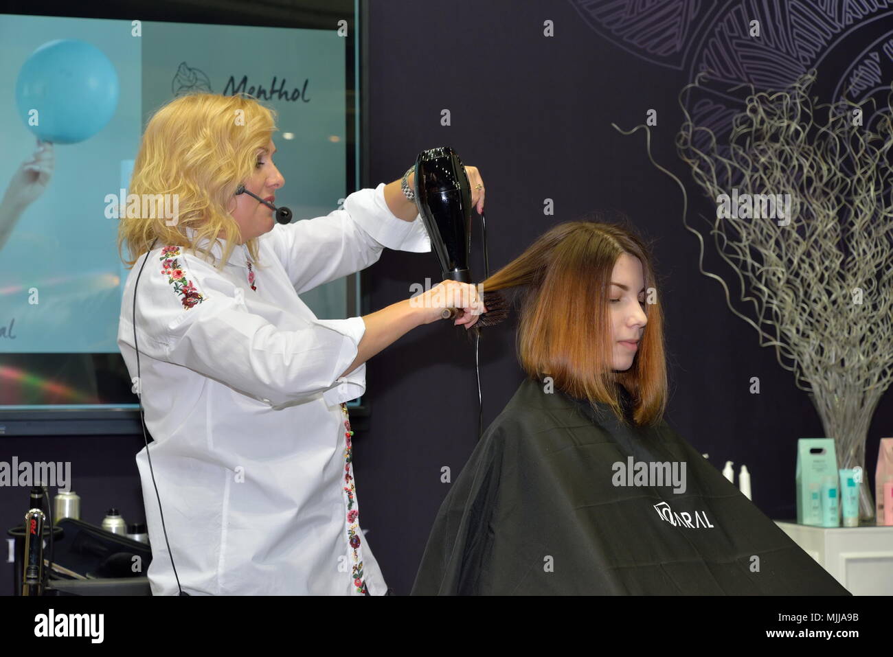 ST.PETERSBURG, RUSSIA - FEBRUARY 23, 2018: Stylist hair makes styling a client on a master class of beauty salon, Kaaral at the festival of beauty Nev Stock Photo