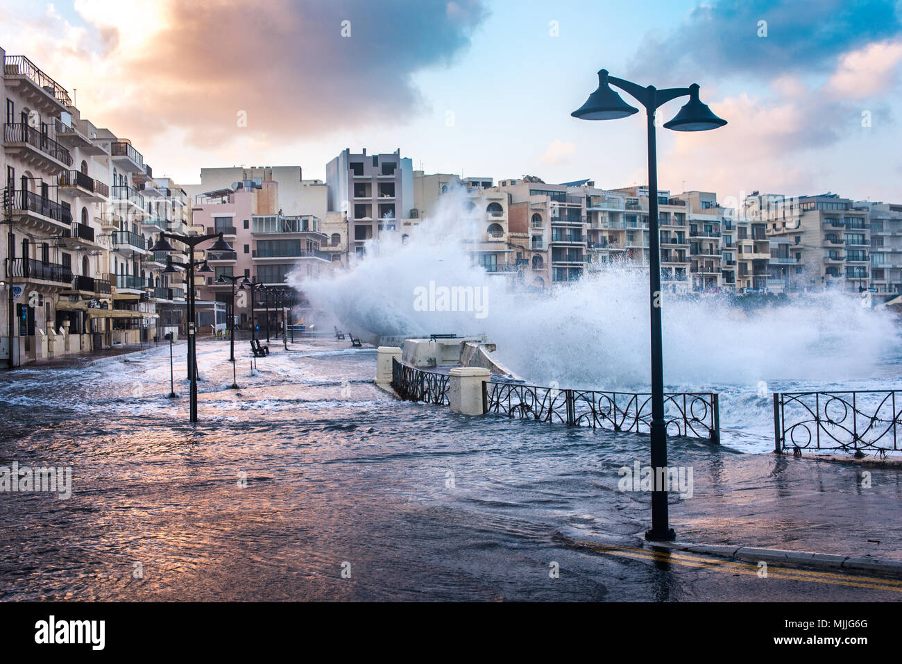 Marsalforn, Malta - January 2, 2018: Big waves are crashing into the Marsalforn promenade. The village of Marsalforn is on the north caost of Gozo, which is an island of the Maltese archipelago and the second-largest island of Malta. Stock Photo